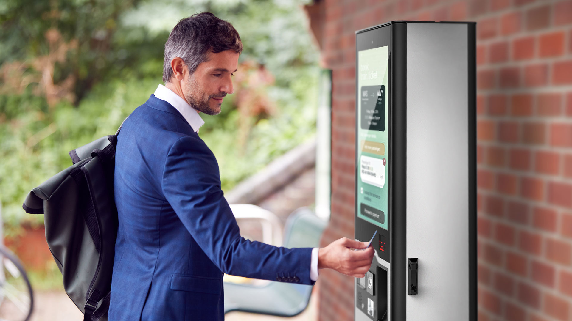 Mann nutz Outdoor für Ticketing an einem Bahnhof