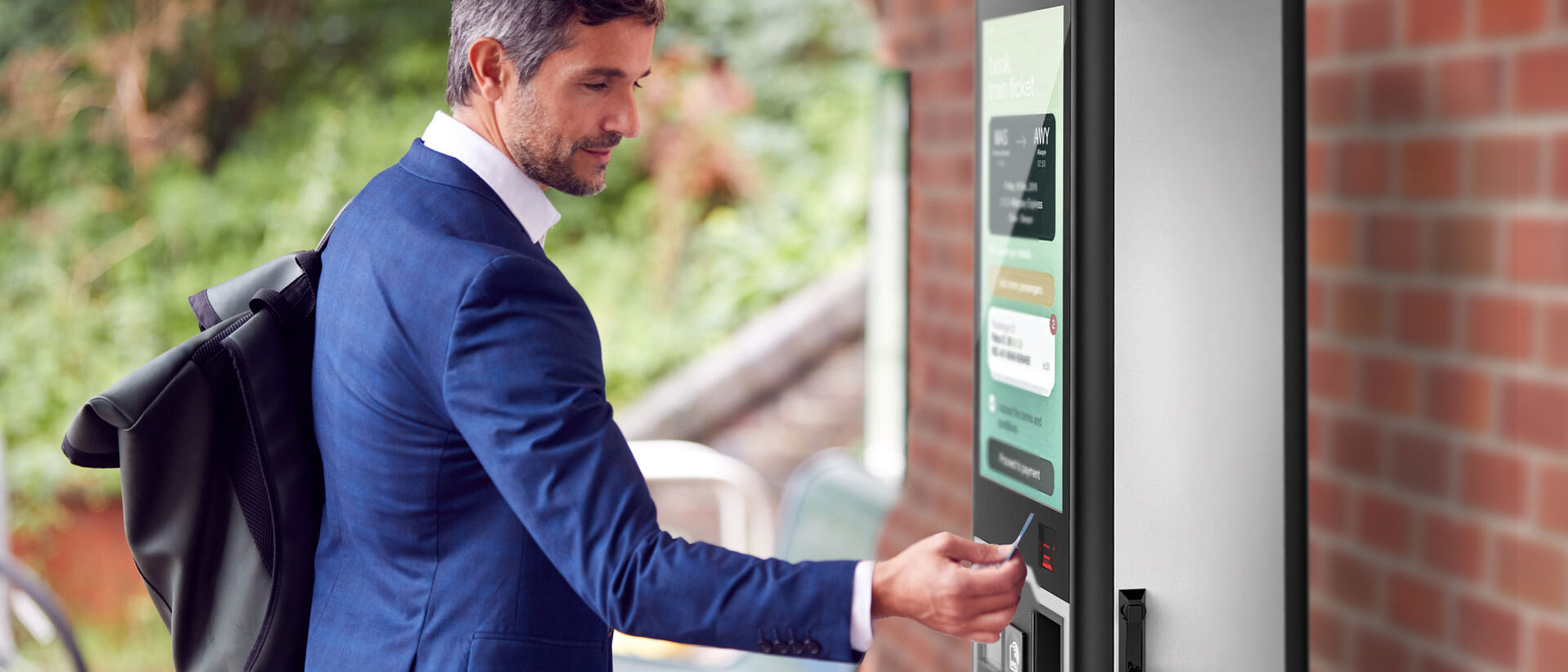 Mann nutz Outdoor für Ticketing an einem Bahnhof